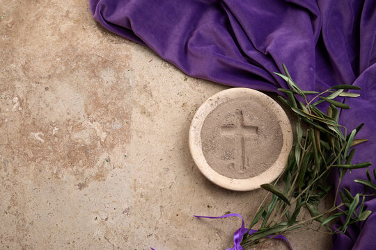 Ash wednesday ashes and olive branches on purple cloth