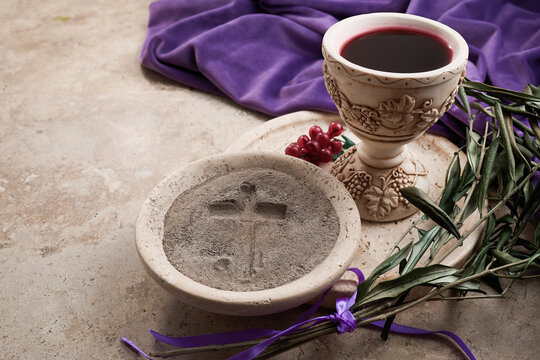 Lent ashes, communion chalice, and olive branches on stone