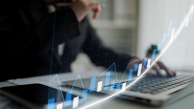 A businessperson analyzes stock market trends on a laptop, showcasing a digital graph overlay that symbolizes financial growth and investment decision-making. Copula - Powered by Adobe