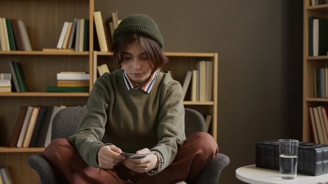 Teenage girl in casual clothes describing pictures on inkblot cards to female psychotherapist during therapy session in counselling office