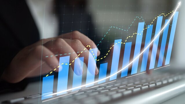 A professional individual types on a keyboard with financial graphs and charts displayed on a screen, illustrating concepts of growth, progress, and data analysis in a modern office. Copula - Powered by Adobe