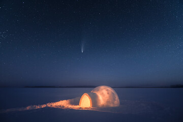 Wintry scene with snowy igloo and starry night sky. Fantastic winter landscape glowing by star...