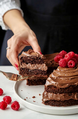 Woman holding a slice of chocolate cake
