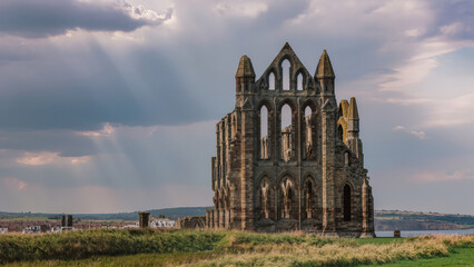 Fototapeta premium Old Gothic Monastery Near Stormy Sea, Weathered Stone Arches Along Windswept Shoreline Landscape