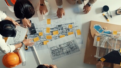 Time lapse of smart architect engineer writing building structure idea on note and stick on blueprint. Aerial view of manager working together with diverse colleague and show house plan. Alimentation.