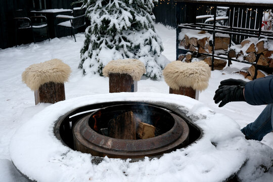 Cozy winter gathering around a warm fire pit in a snowy setting