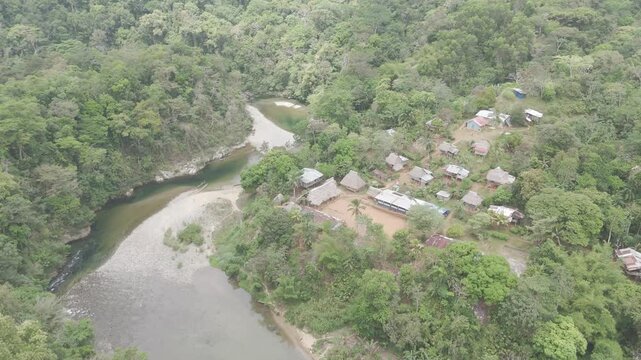 Aerial drone view of Embera Drua indigenous village located along the Chagres River in Colon, Panama. This cinematic scene showcases traditional huts, river landscape, and surrounding tropical rainfor