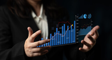 A business professional displays dynamic financial data through interactive graphics and charts, ideal for conveying analytics and strategies in a modern office setting. Scalp