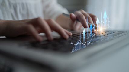 Close-up of hands typing on a laptop keyboard with a digital graph overlay depicting growth and analytics, showcasing modern data analysis in a professional environment. Scalp