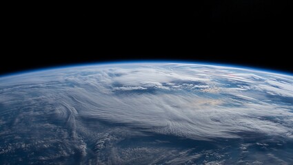 The view shows Earth from space with a clear line of the horizon. The atmosphere creates a blue glow around the planet. The surface has visible cloud patterns.