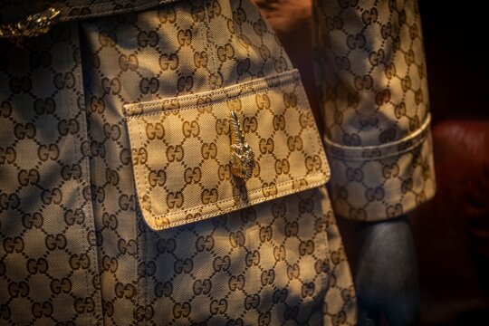 Milan, Italy - 2026, 13 Jan: Close-up of Gucci FW25 coat featuring iconic monogram pattern, gold hardware, and luxurious beige fabric, capturing modern Italian elegance