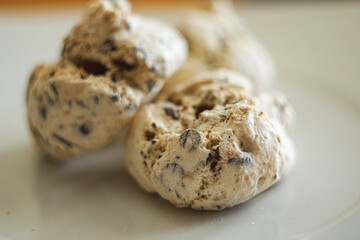 Homemade meringue cookies with dark chocolate chips and nuts on a white plate. Crispy sweet dessert texture close up.