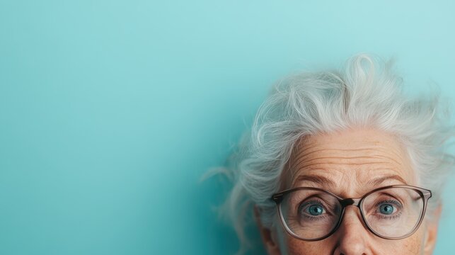 A close-up portrait of a thoughtful elderly woman with striking grey hair and glasses, capturing her wisdom and emotions against a vibrant turquoise background.