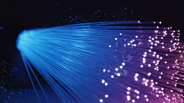 Fiber optic cables with glowing blue and purple light on dark background with communication concept 4k video