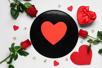 Vinyl disc with gift box, rose flowers, music notes and decorative hearts on white background