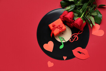Vinyl disc with rose flowers, gift box, paper hearts and music notes on red background