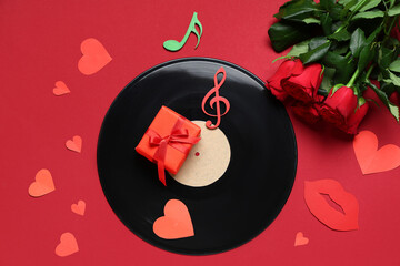 Vinyl disc with rose flowers, gift box, paper hearts and music notes on red background