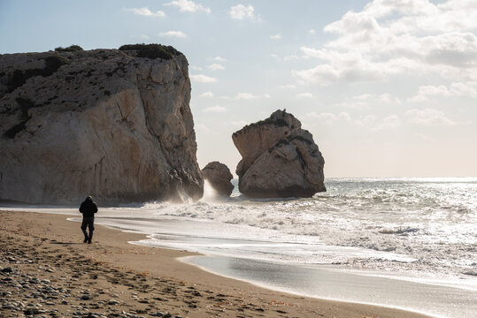 Man walking on remote aphrodite's rock beach in paphos cyprus