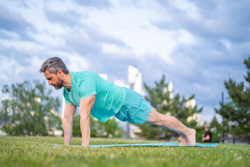 Man doing plank exercise. Summer sport outdoors. Fitness mature man workout shows fitness body strength. Fitness training. Fitness personal motivation.