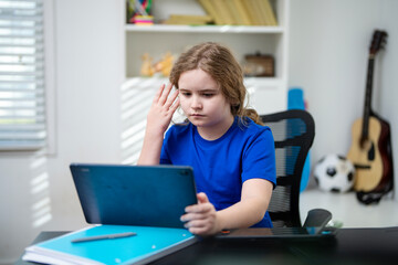 Child learning by typing on laptop for school. Kid learning from educational video on laptop. Kid learning from home using laptop. Child learning in remote education with laptop.