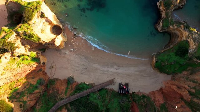 Top Down Aerial rise of Praia do Camilo Beach and Cliffs in Lagos, Algarve, Portugal