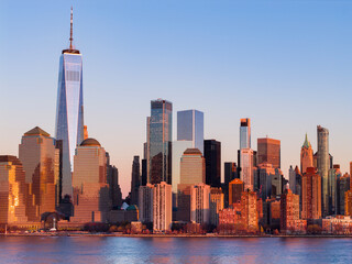Manhattan urban landscape in New York at dusk. NYC panoramic dusk cityscape centered on Manhattan. Manhattan panoramic skyline of New York City at dusk. Manhattan waterfront panoramic cityscape.