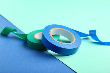 Insulating tape rolls on color background, closeup