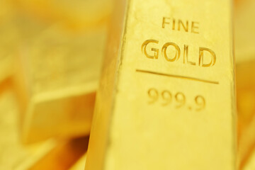Macro view of a pure gold ingot showing 999.9 purity stamp. Concept of financial security, safe...