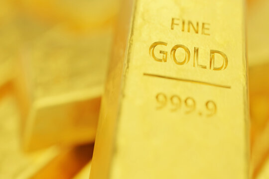 Macro view of a pure gold ingot showing 999.9 purity stamp. Concept of financial security, safe haven assets, and gold trading. Sharp focus on gold texture for banking and investment backgrounds.