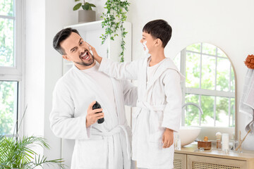 Obraz premium Happy father and his little son applying shaving foam on faces in bathroom