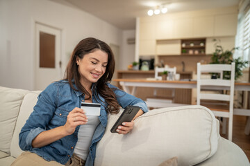 Woman shopping online using credit card and smartphone at home