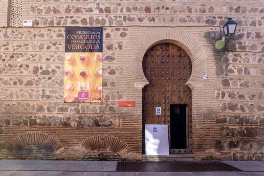 Toledo, Spain, 08.10.21. Toledan Mudejar style arch with wooden entry doors to the Museum of the Councils and Visigoth Culture (Church of San Roman), stone and brick facade.