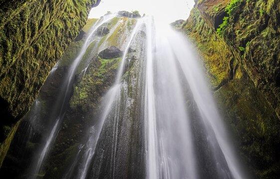 Iceland waterfall flowing through mossy rocky gorge