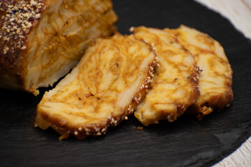 Vegan seitan roast- spicy wheat gluten as meat protein alternative, sliced on slate board