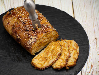 Vegan seitan roast- spicy wheat gluten as meat protein alternative, sliced on slate board