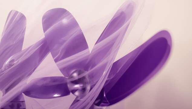 lavender fan blades with a mesh cover against a beige wall backdrop