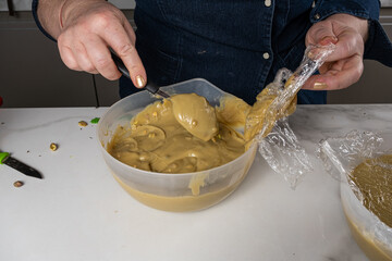 Confectioner stirring the pistachio cream in the bowl.