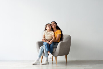 Look There. Amazed Mom And Her Little Daughter Sitting In Armchair And Looking Up Above Their Heads...
