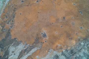 Minimalist rural landscape with dry meadow and patches of melting snow aerial drone shot