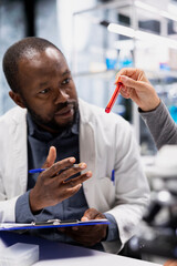 Researcher and lab clinical research associate testing blood samples for adverse drug reactions. Laboratory coworkers collaborating, evaluating sanguine fluid vials, developing medication, camera A