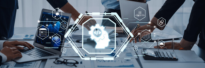A diverse team collaborates in a modern office. A technology interface displays gears and data management concepts, emphasizing innovation and teamwork. Trope