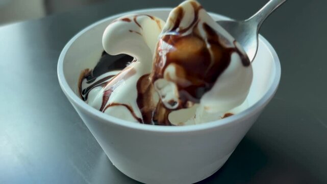 Eating Soft Serve Vanilla Ice Cream with Chocolate Sauce