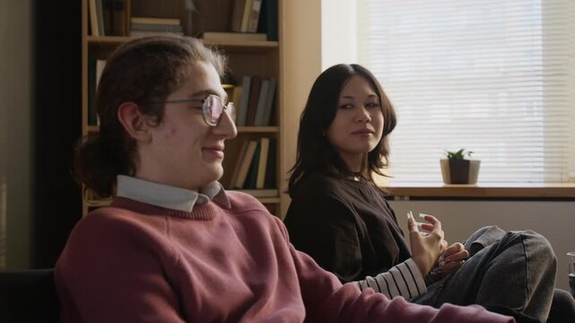 Upset teenage girl discussing relationship problem with boyfriend in couples counseling while partner remaining resentful during therapy session
