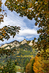 Scenic autumn mountain landscape with Trzy Korony peak and colorful forest in the Pieniny Mountains, Poland. Beautiful nature view under blue sky with clouds. © Ronin