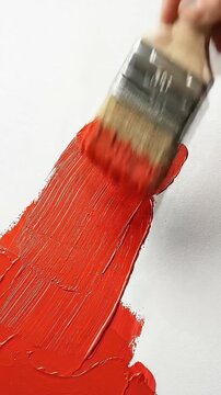 Artist Painting Vibrant Red Stroke with Brush on White Canvas
