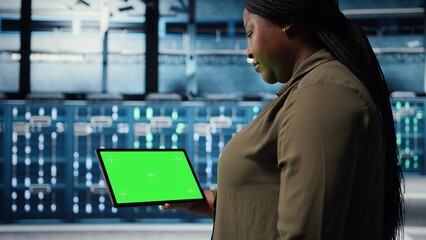 Admin in data center using green screen tablet to deploy new server architecture. Server hub worker using chroma key device to do rollout of cybersecurity framework, protecting data, camera A