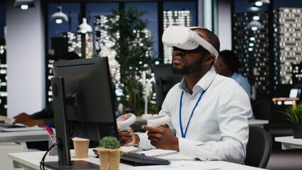Black businessman using VR headset and gadgets to draft a project plan, engaged in forecasting projections and documenting risk assessment results. Solve tasks with virtual reality.