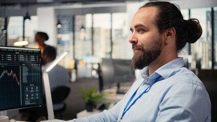 Close up of happy day trader analyzes stock market price candlestick charts, making buy and sell decisions in office. Cheerful stockbroker places client orders using trading platform