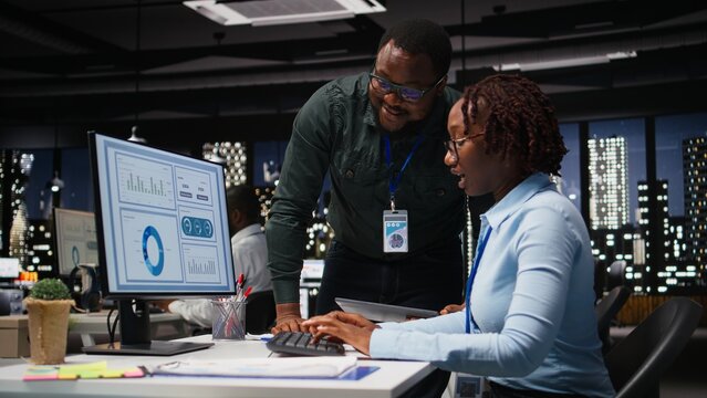 Black team of business colleagues analyzing data insights on desktop pc in office, consulting the analysis forecast before developing a new strategy for the enterprise activity. - Powered by Adobe