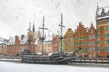 Beautiful ancient sail ship moored on the embankment of frozen Motlawa river in Gdansk